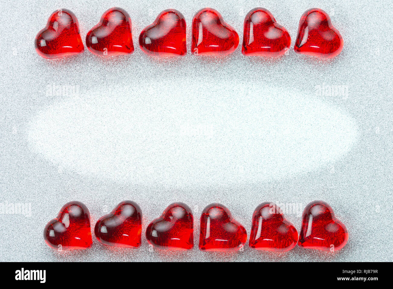 Valentinstag, Hochzeit Karte Hintergrund mit zwei Reihen der glänzenden Herzen liegen auf ihren Seiten auf einem silbernen Brocade Hintergrund Stockfoto
