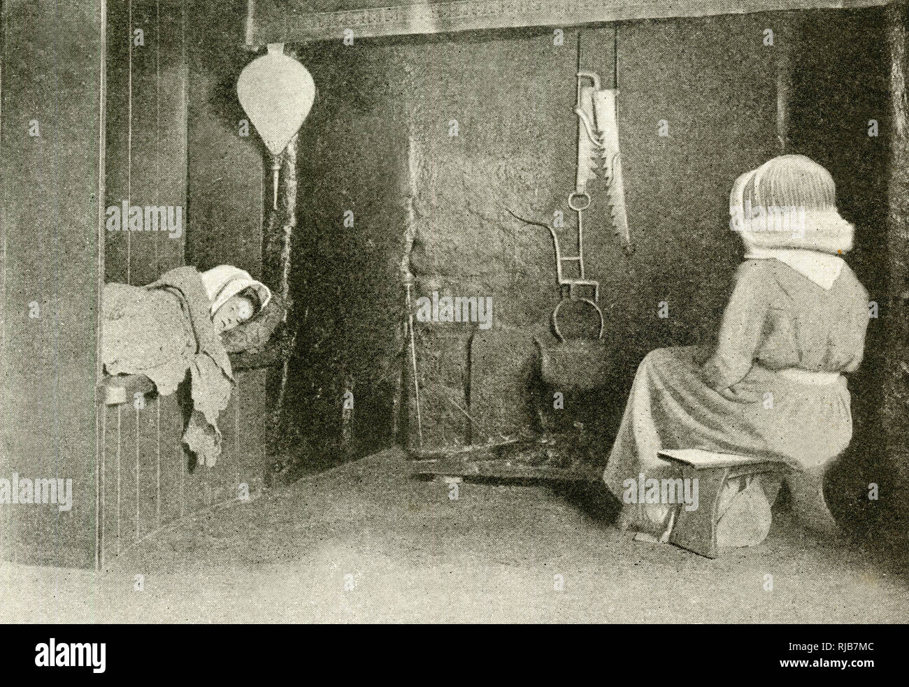 Hütteninnenraum mit Mutter und schlafendem Kind, Devon Stockfoto