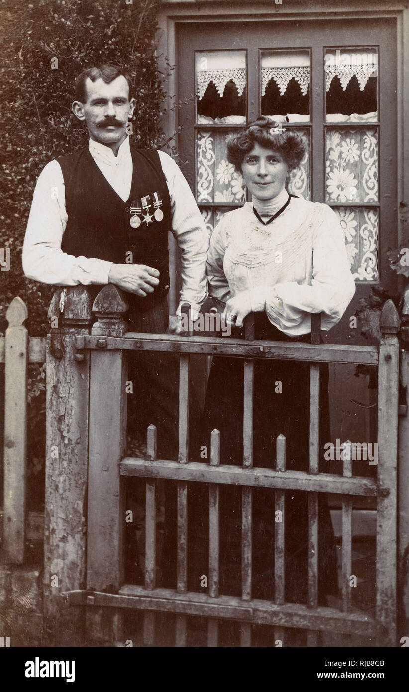 Ein Paar am Tor, ein Mann mit Boer war Medaillen Stockfoto