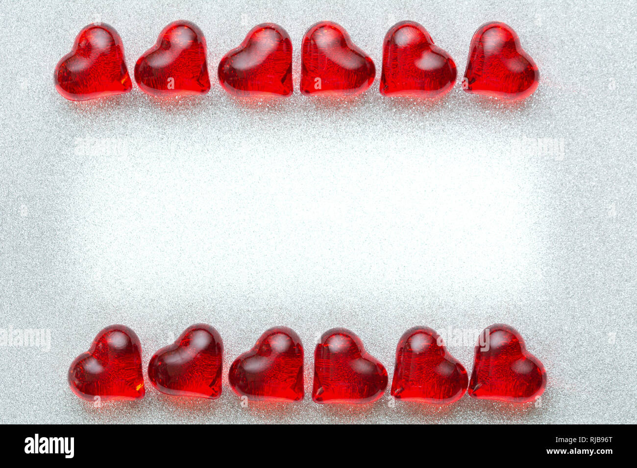 Valentinstag, Hochzeit Karte Hintergrund mit zwei Reihen der glänzenden Herzen liegen auf ihren Seiten auf einem silbernen Brocade Hintergrund Stockfoto