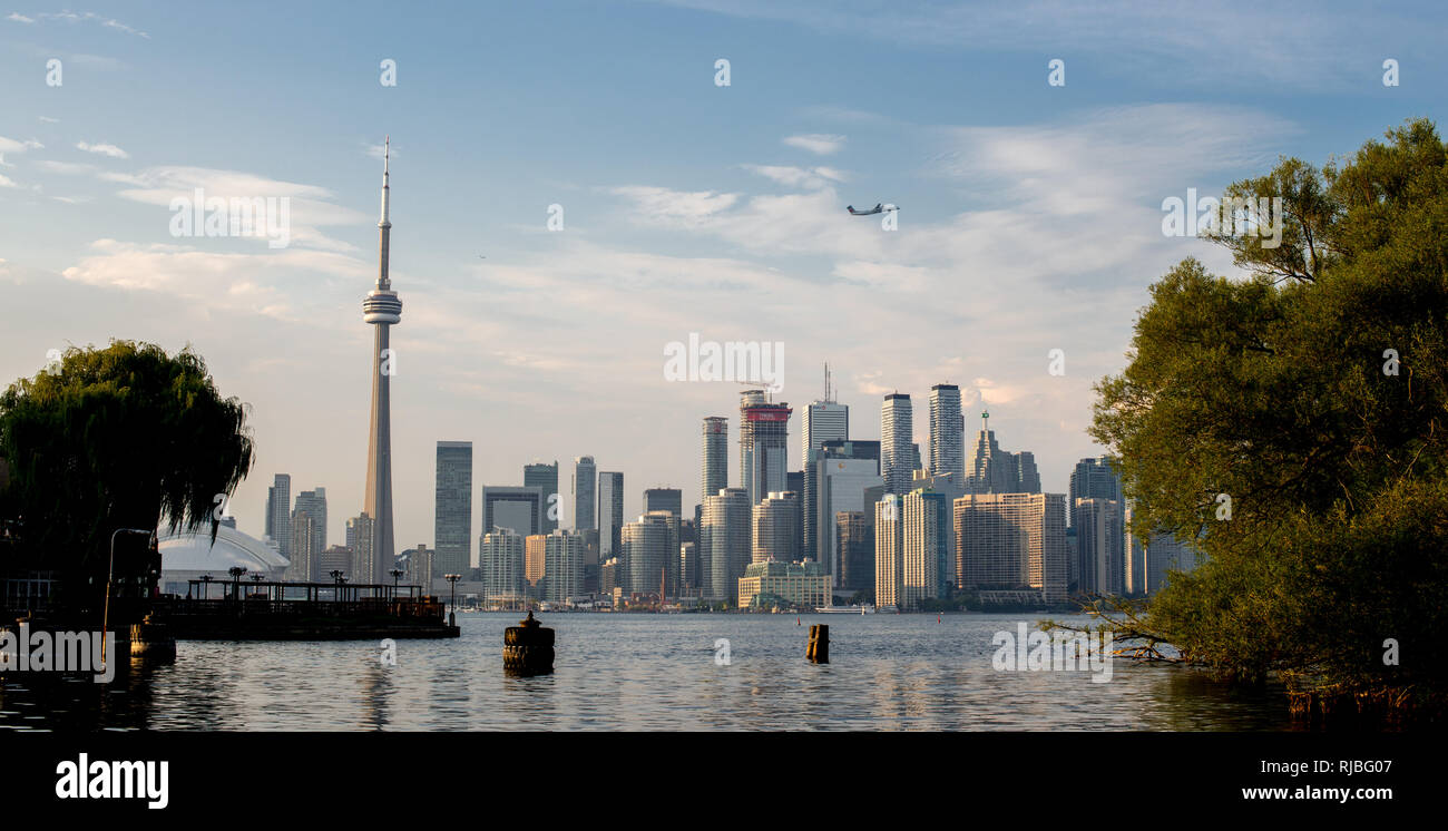 Blick auf Flugzeug durch die Toronto Skyline mit dem CN Tower fliegen, vom Toronto Islands. Toronto, Ontario. Stockfoto