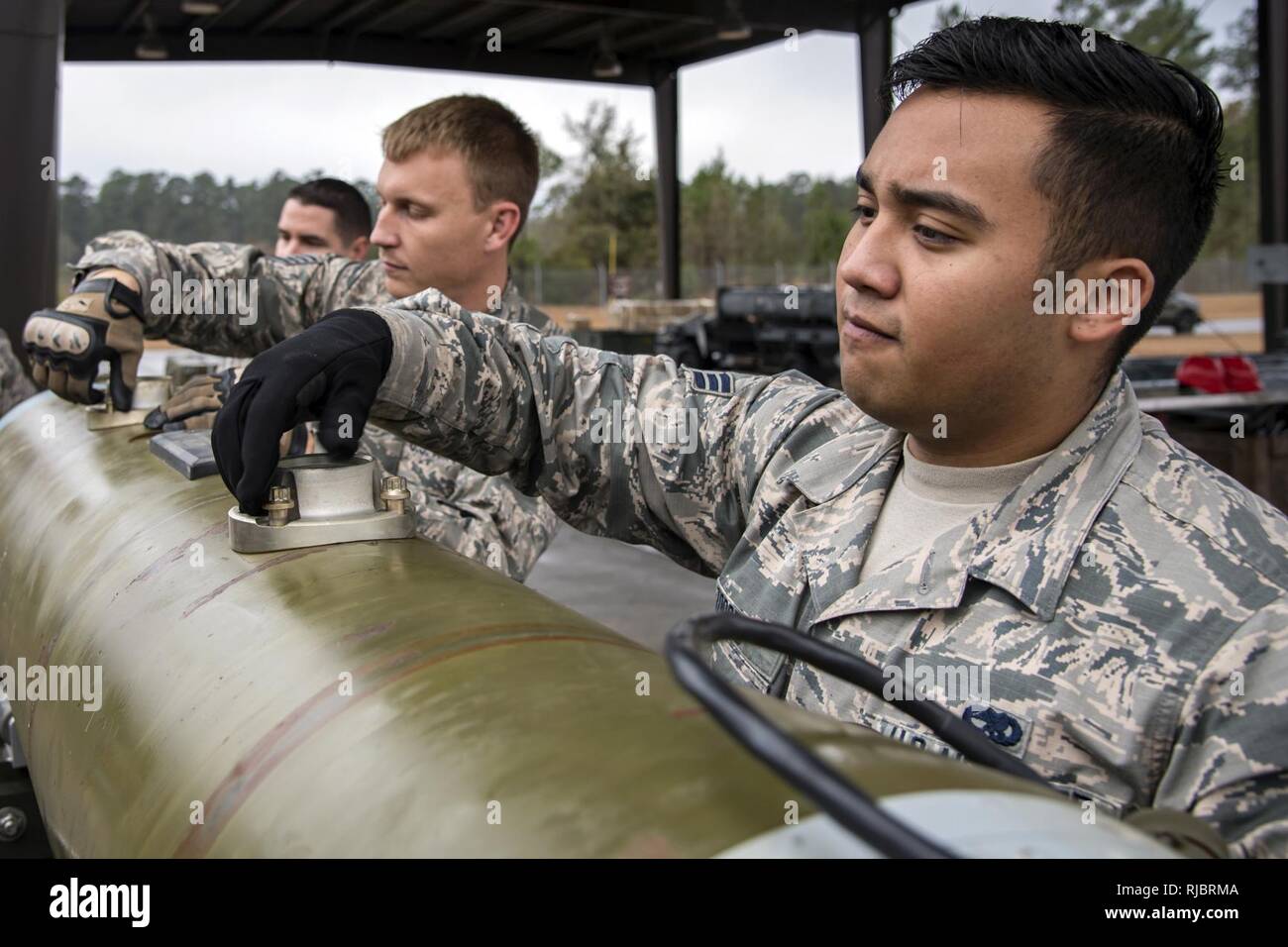 Airman 1st Class Jordon Torres, 23 d Maintenance Squadron (MXS), Munition Spezialist, rechts, und Staff Sgt. Clinton Parkins, 23d MXS Linie Lieferung Supervisor, Drehungen Schrauben auf den Stift Adapter einer Joint Direct Attack Munition, Jan. 11, 2018, bei Moody Air Force Base, Ga. Die 23d MXS ein Kampf Munition Klasse gewöhnen zu helfen und die Bereitschaft, Ihre Flieger gut in einer bereitgestellten Umgebung durchführen zu verbessern. Stockfoto