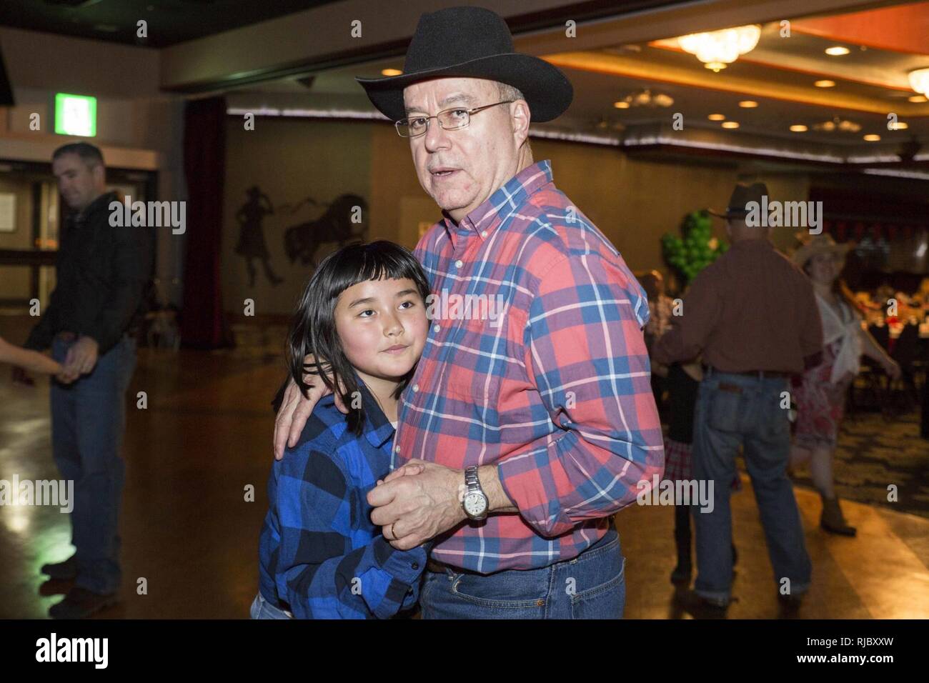 Service für Mitglieder und ihre Töchter nehmen an der Stiefel'n Belles Daddy-Daughter Dance an Marine Corps Air Station Iwakuni, Japan, Jan. 13, 2018. Väter und Töchter tanzten, machte Bilder, Spiele gespielt und gewonnen Gewinnspiel Wettbewerbe, wie sie die Nacht gemeinsam erstellt und Erinnerungen zusammen. Stockfoto