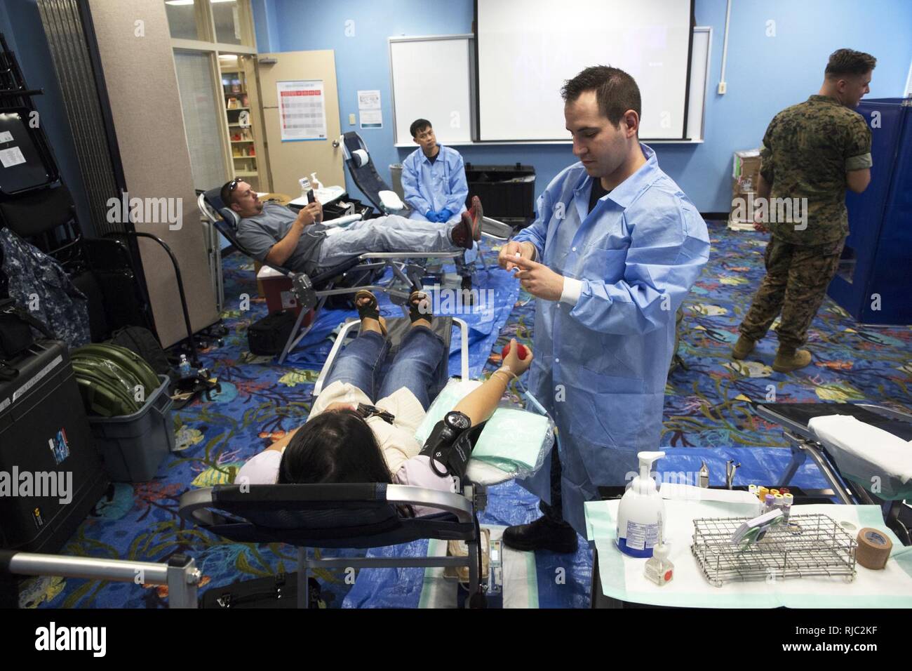 Seaman Davis James bereitet intravenösen Schläuche vor dem Sammeln von Blut eines Spenders während einer US Pacific Command Armed Services Blut Bank Center Blood Drive Nov. 3, 2016 in der Bibliothek an Bord Camp Foster, Okinawa, Japan. Die Bibliothek ist eine Initiative, die unter der Schirmherrschaft des ASBBC medizinische Einrichtungen in Okinawa und in der asiatisch-pazifischen Region zu unterstützen. Während der Fahrt, Spender ein umfassendes Screening unterzogen, um sicherzustellen, dass Sie gesund waren und bereit, Blut zu spenden. Die ASBBC ist der wichtigste Anbieter von Blut und Plasma für Übungen und Operationen in der gesamten Region. Jame Stockfoto