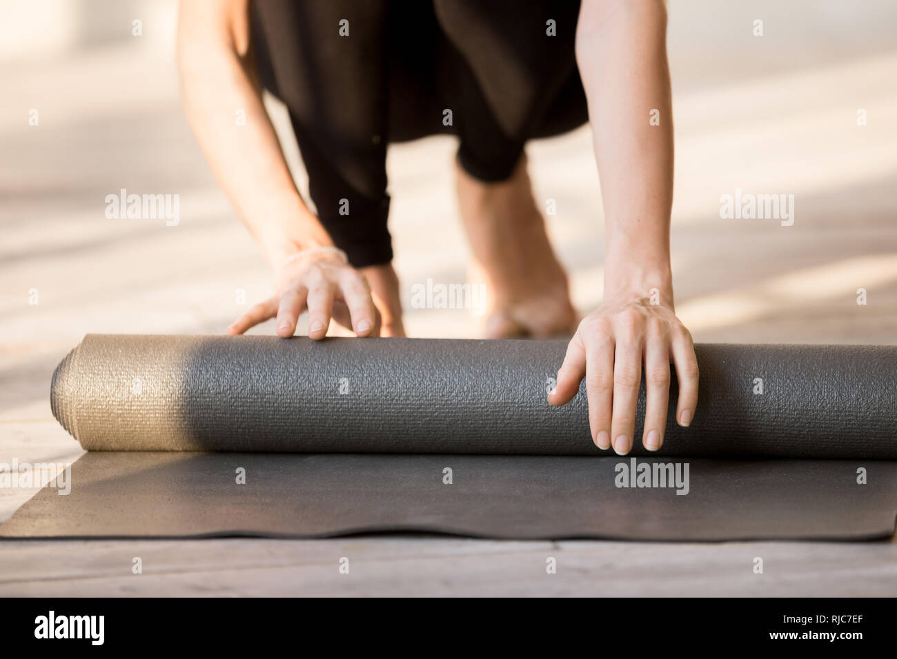 In der Nähe von sportlichen weiblichen Rollen Yoga Matte nach dem Training Stockfoto