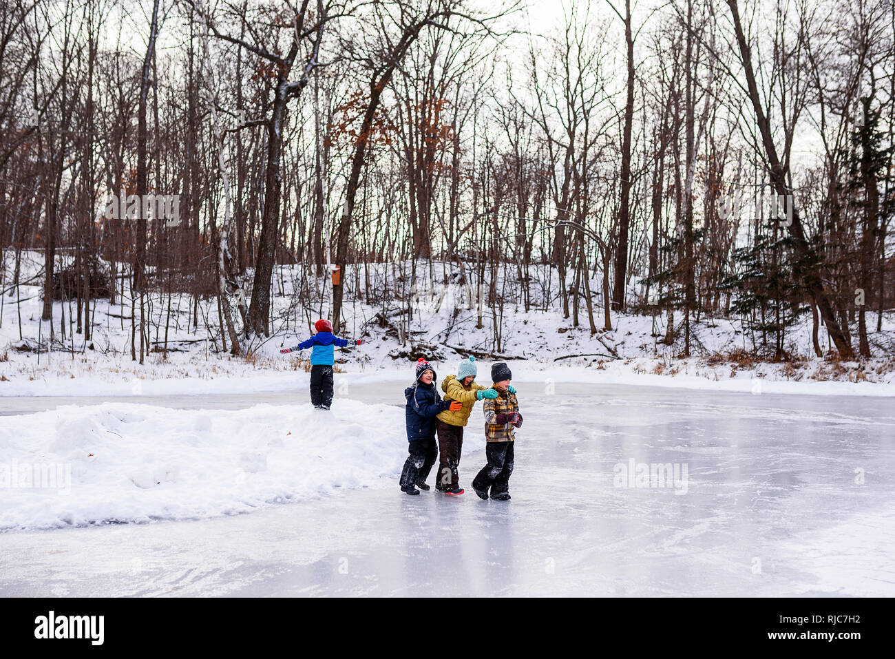 Vier Kinder zu Fuß auf einem zugefrorenen See, Wisconsin, United States Stockfoto