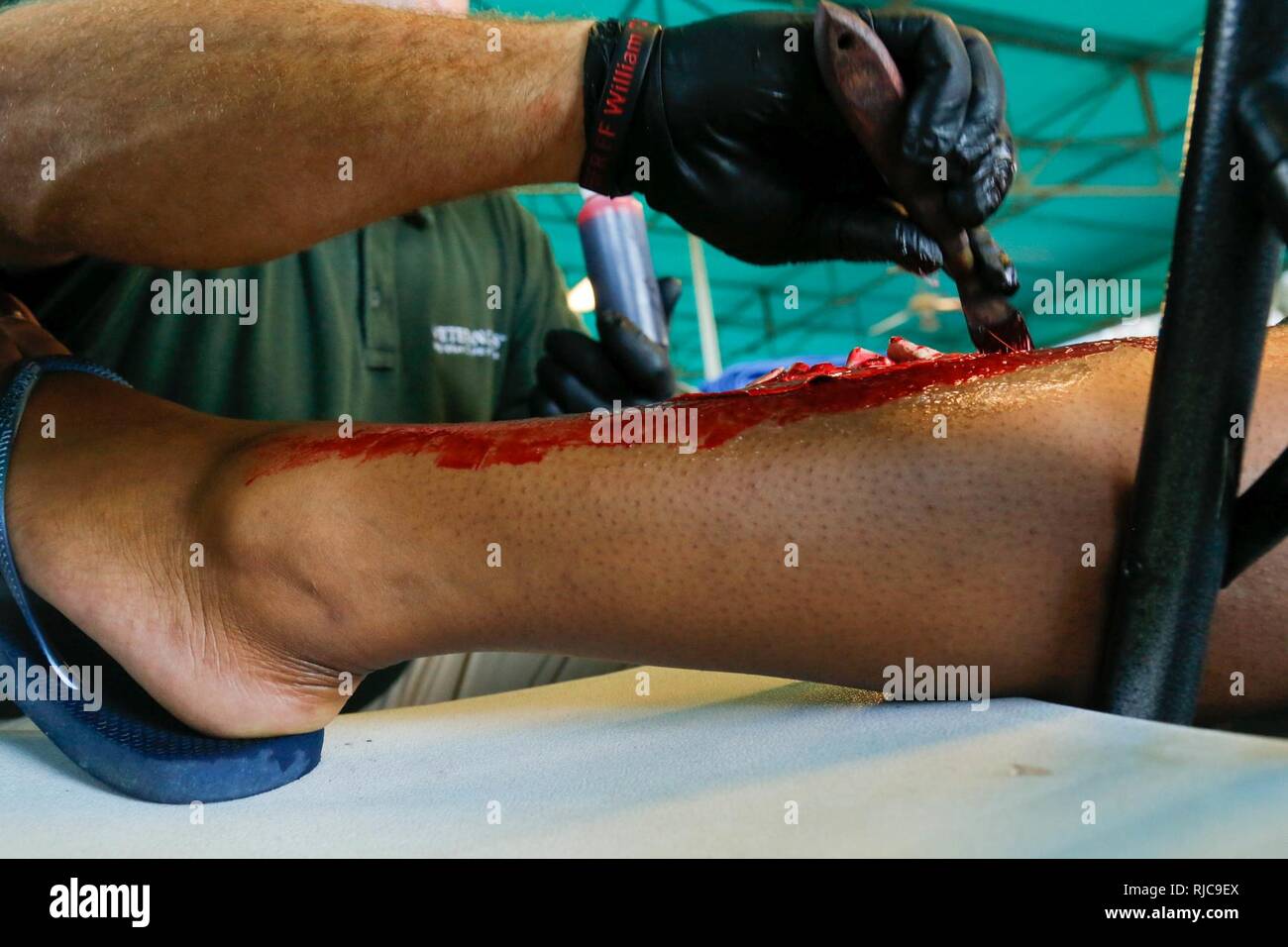 Rohm Kern eine Make-up-Artist von Südflorida, schafft simulierten verletzt zu einem Freiwilligen in eine gemeinsame Übung auf dem Homestead-Miami Speedway in Miami, Fla., Jan. 11, 2018. Diese jte konzentrierte sich auf den Aufbau von Kapazitäten und der nahtlose Übergang zwischen den örtlichen Ersthelfern und die Unterstützung durch die Nationalgarde und aktiven Soldaten zur Verfügung gestellt. (U. S. Armee Stockfoto