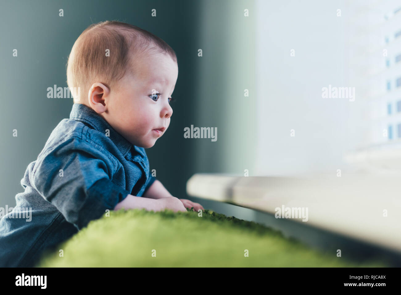 Neugeborenes Baby boy Portrait auf grünen Teppich Nahaufnahme. Mutterschaft und neues Leben Konzept Stockfoto