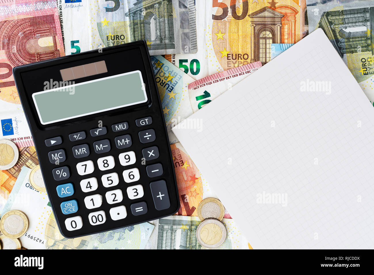 Taschenrechner und Notizblock mit Bargeld im Hintergrund Stockfoto