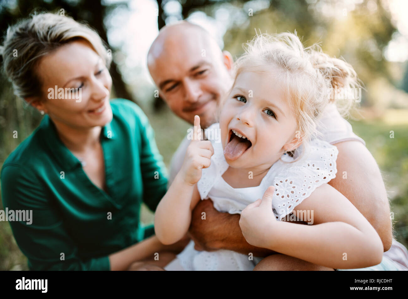 Junge Familie mit einer kleinen Tochter im sonnigen Sommer Natur. Stockfoto
