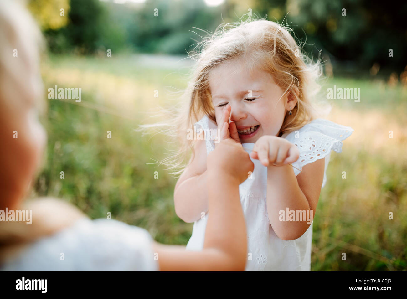 Zwei kleine Mädchen Freunde oder Schwester spielen im Freien im sonnigen Sommer Natur. Stockfoto