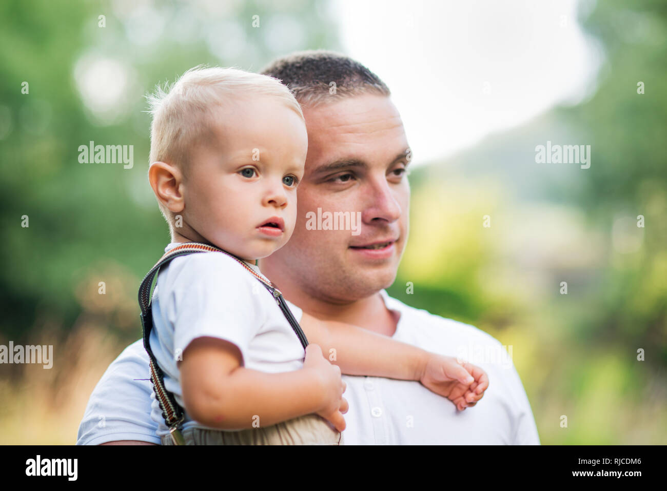 Junger Vater einen kleinen Toddlersohn im sonnigen Sommer Natur. Stockfoto