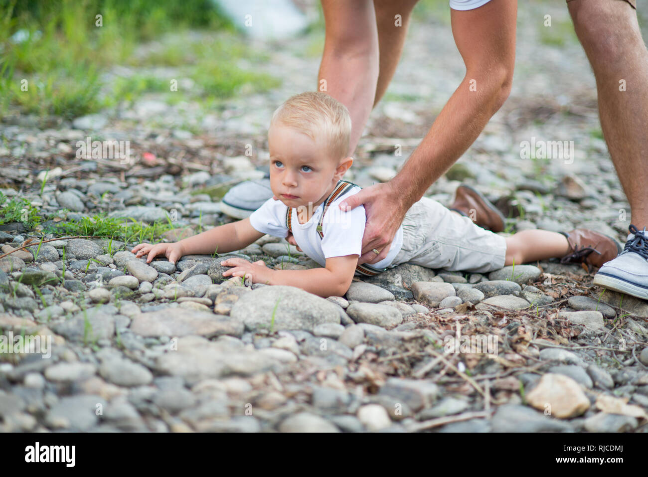 Nicht erkennbare Vater Anheben einer Kleine Kleinkind Sohn im sonnigen Sommer Natur. Stockfoto