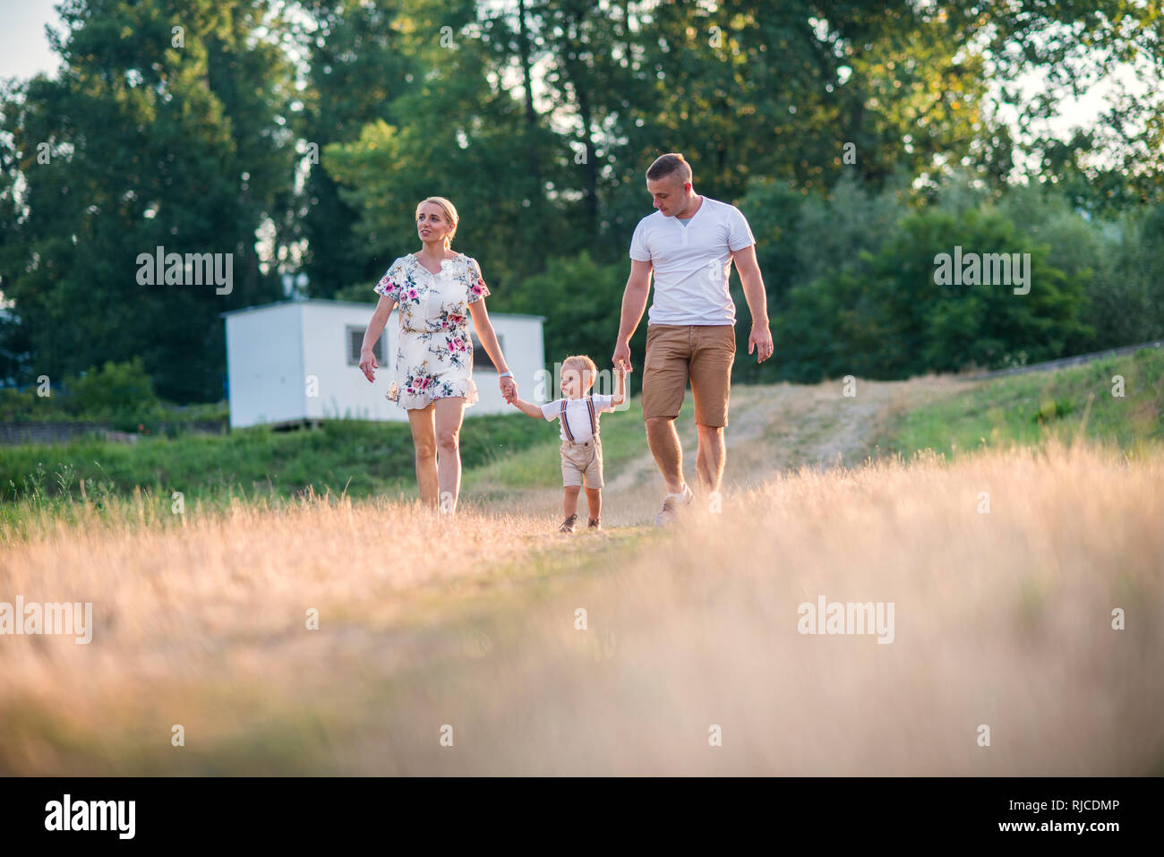 Junge Familie mit einem kleinen Kind Junge im sonnigen Sommer Natur. Stockfoto