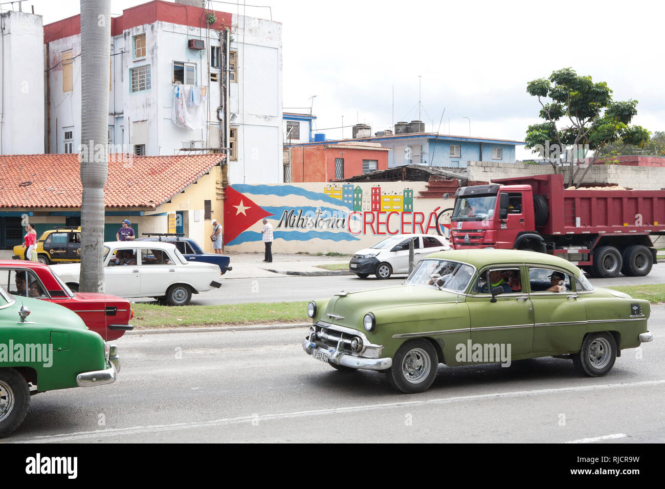 Verkehr auf einer Straße in Havanna Kuba mit kubanischen Flagge an der Wand gemalt Stockfoto