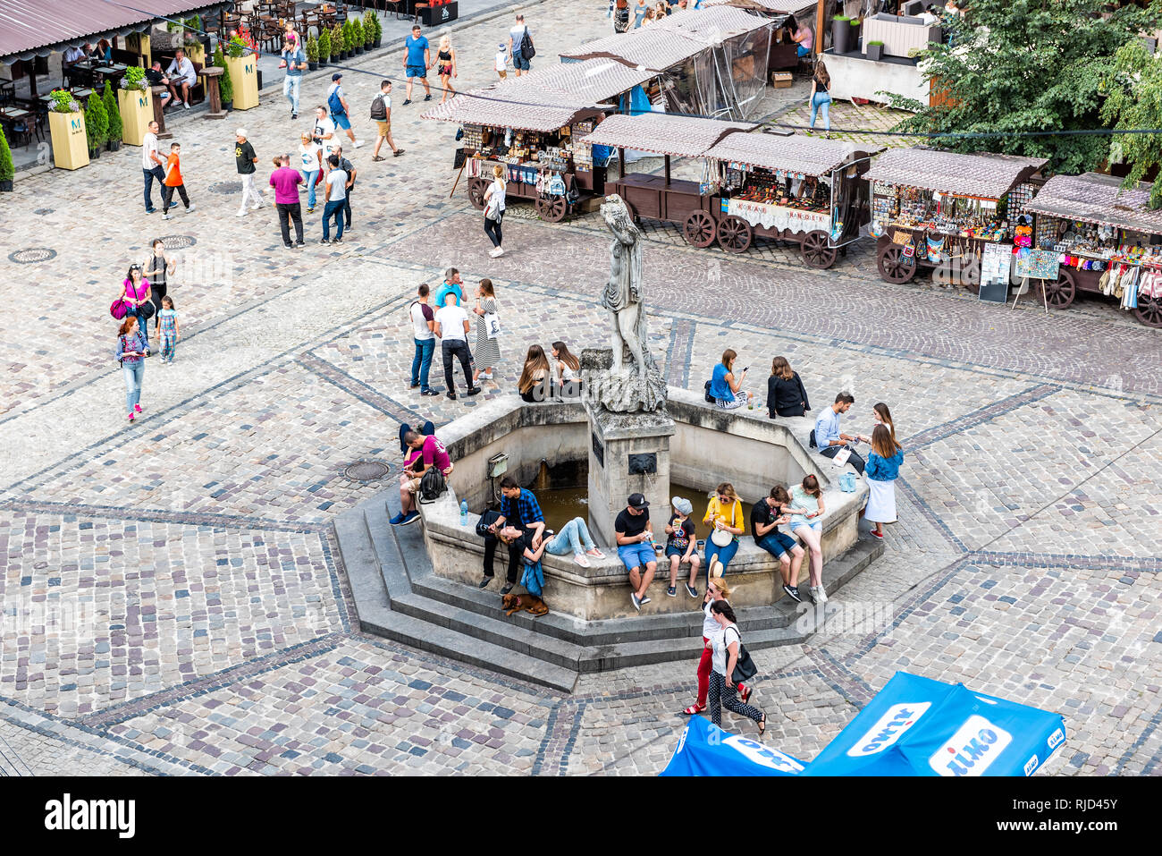 Lemberg, Ukraine - Juli 30, 2018: Antenne Hohe Betrachtungswinkel und der historischen Ukrainischen polnische Stadt in der Altstadt Marktplatz mit Neptunbrunnen und viele Mitarbeiter Stockfoto