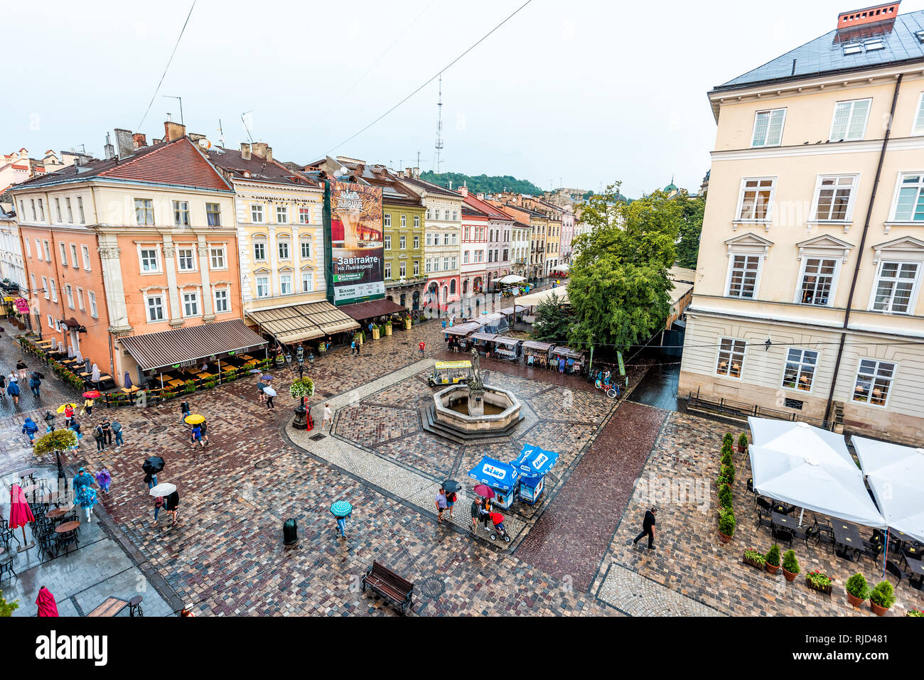 Lemberg, Ukraine - 31. Juli 2018: Antenne Hohe Betrachtungswinkel und der historischen ukrainischen Stadt in der Altstadt Marktplatz mit Cafe Restaurant Wasserfontäne in wet Stockfoto