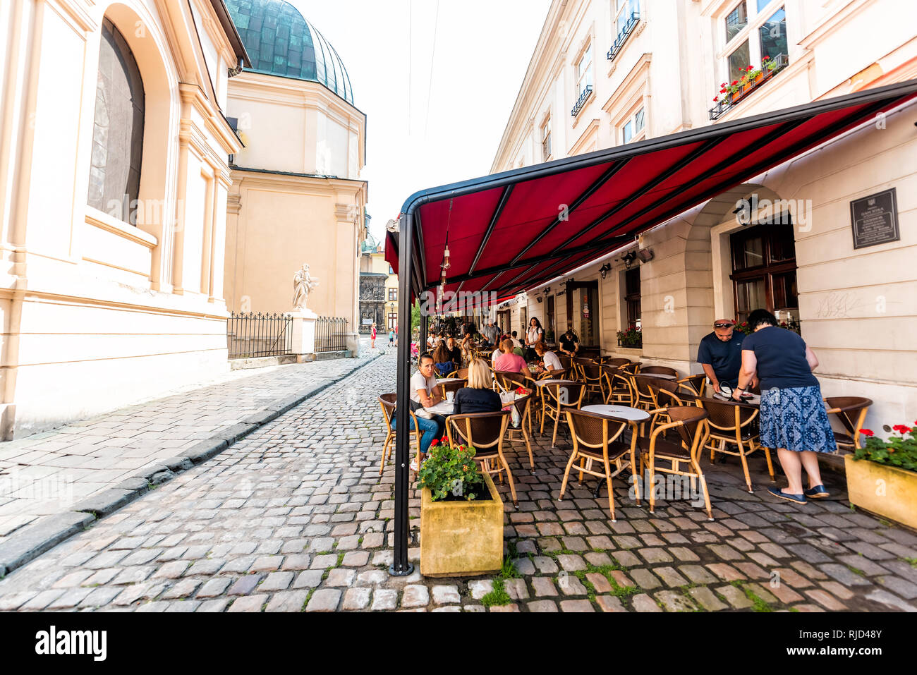 Lemberg, Ukraine - August 1, 2018: Street im historischen Ukrainischen polnischen Lvov Stadt bei Tag mit überdachten cafe Svit Kavy in der alten Stadt und Menschen sitzen, die von Stockfoto