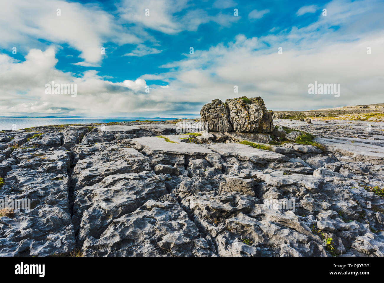 Stark verwitterte Kalkstein Pflaster mit großen findling an Poulsallagh in der Nähe der Atlantikküste des Burren, County Clare, Irland Stockfoto