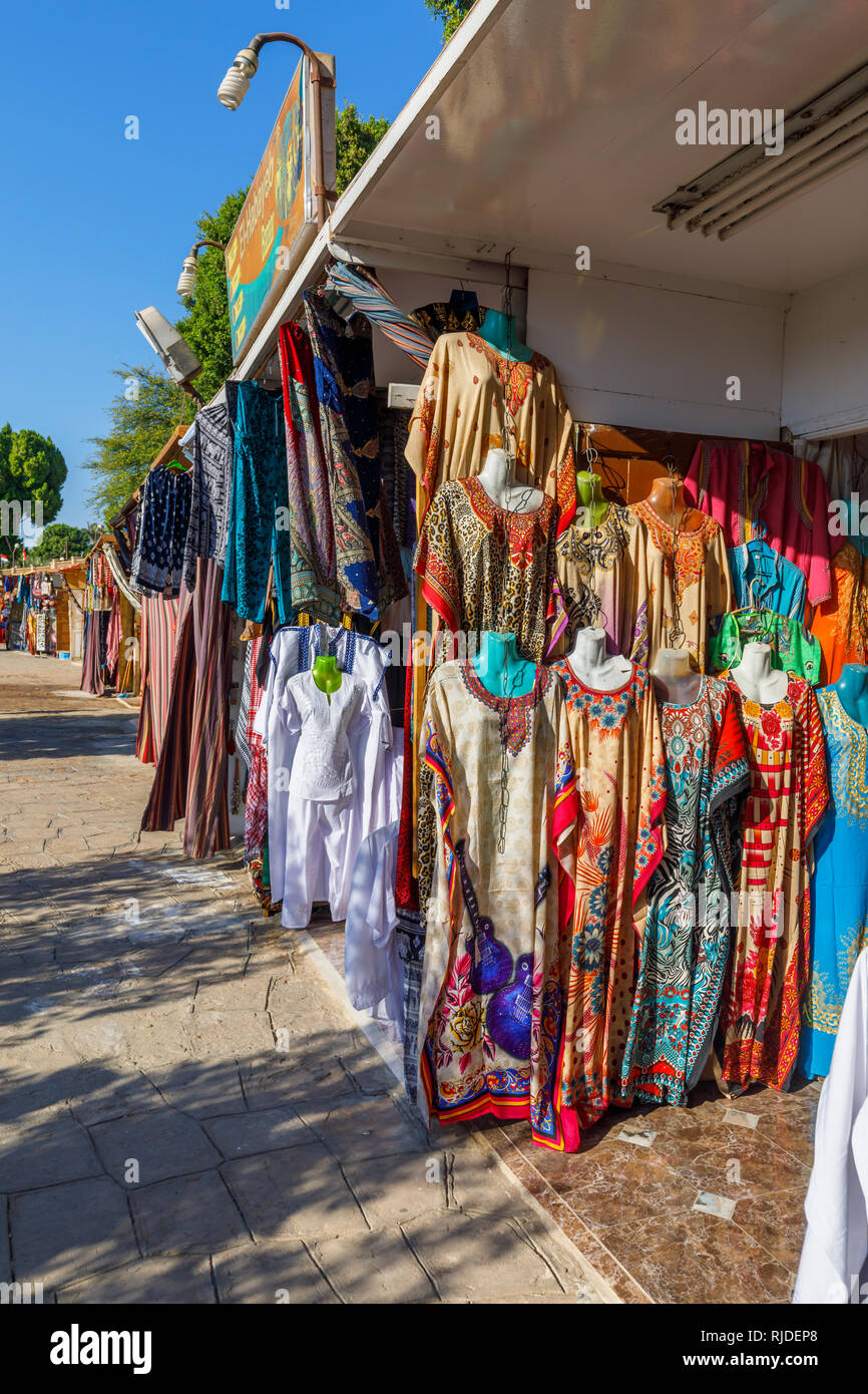 Markt am Ufer des Nils durch den Tempel von Kom Ombo, Oberägypten Verkauf traditionelle bunte galabeyas als Souvenirs für Touristen aus Kreuzfahrten Stockfoto