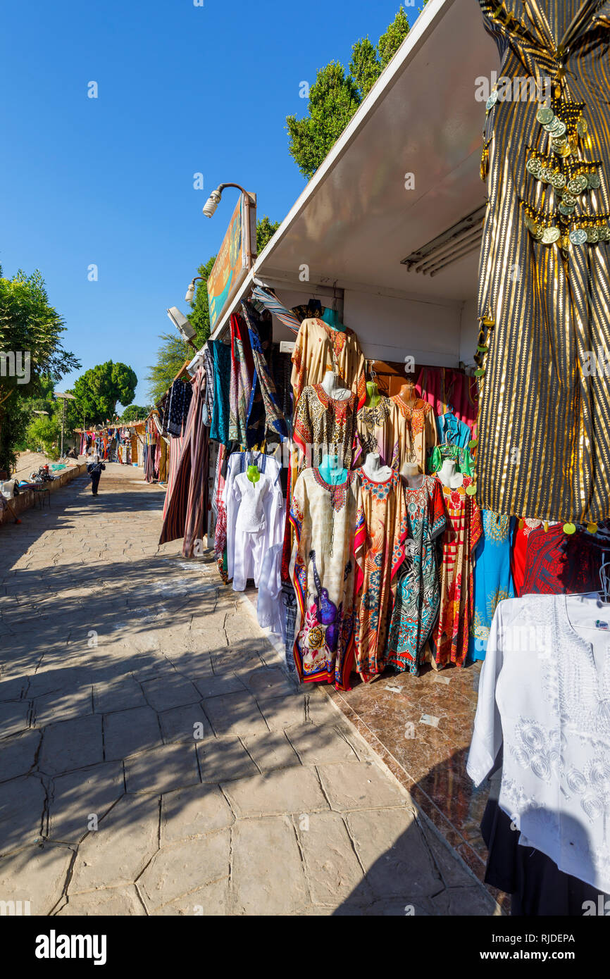 Markt am Ufer des Nils durch den Tempel von Kom Ombo, Oberägypten Verkauf traditionelle bunte galabeyas als Souvenirs für Touristen aus Kreuzfahrten Stockfoto