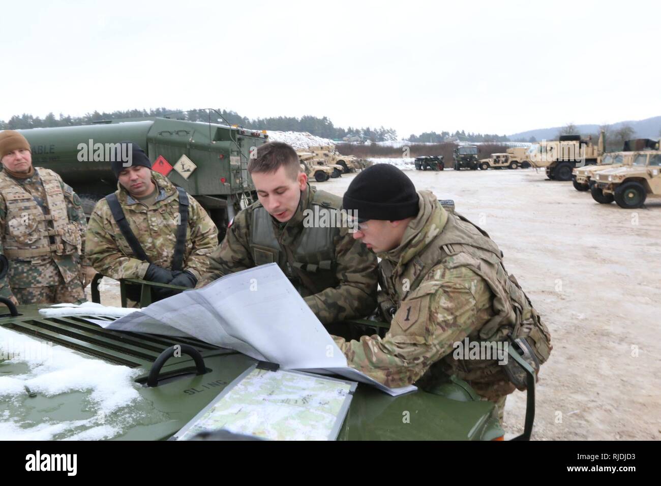 Soldaten aus 82Nd Engineer Battalion, 2nd Armored Brigade Combat Team, 1.Infanterie Division und ein polnischer Soldat ihren Konvoi Route zu besprechen, um Ihre Website chemischen, biologischen, radiologischen, nuklearen und explosiven Reaktion in Vorbereitung für die Alliierten Geist VIII Jan. 22, in Hohenfels, Deutschland 2018. Allied Geist VIII ist so konzipiert, dass multinationale Interoperabilität Ausbildung bei der Feuerwehr und Bataillon ebenen USA und NATO-Effizienz zu verbessern. Stockfoto