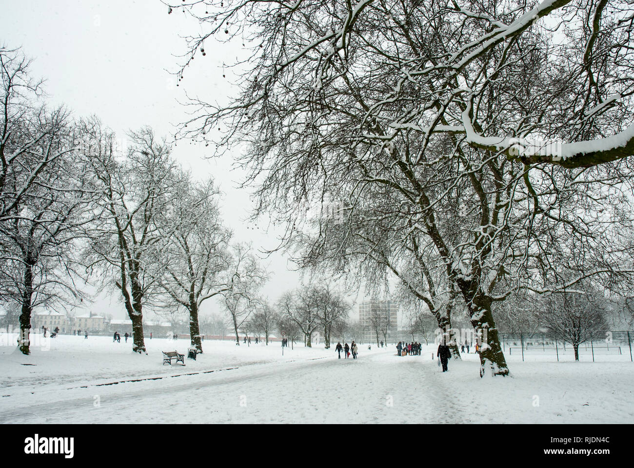 Finsbury Park, Haringey, London. Aktiv schneit mit Bäumen und Park im Schnee wie die Menschen in die Ferne gehen und Spaß haben. Stockfoto