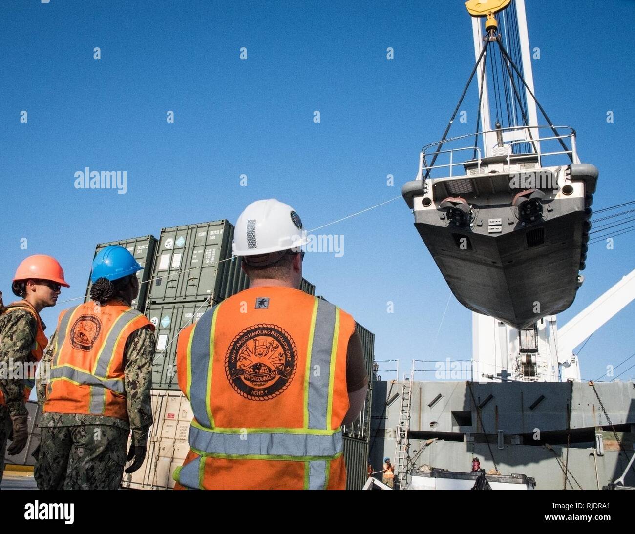 FUJAIRAH, Vereinigte Arabische Emirate (Jan. 17, 2018) U.S. Navy Sailors, zu Naval Cargo Handling Bataillon 1 zugewiesen, die Arbeit mit der Crew der USNS Seay (T-AKR 302) ein Dienstprogramm Boot während Native Fury 18 zu heben. Die Übung ist so konzipiert, Special Purpose Marine-Air - Masse Aufgabe Force-Native Fury Marines und US-Marine Seeleute in maritime Vorpositionierung kraft Operationen zu trainieren und zielt darauf ab, die Kenntnisse zu verbessern, erweitern die Zusammenarbeit im maritimen Fähigkeiten zu verbessern und die langfristige Stabilität in der Region und die Interoperabilität zwischen den Vereinigten Arabischen Emiraten und den USA. Stockfoto