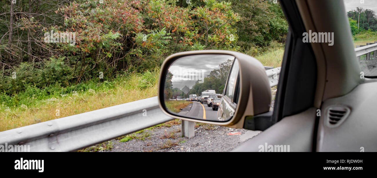 Einem seitlichen Rückspiegel reflektiert einen Stau auf der Autobahn. Stockfoto