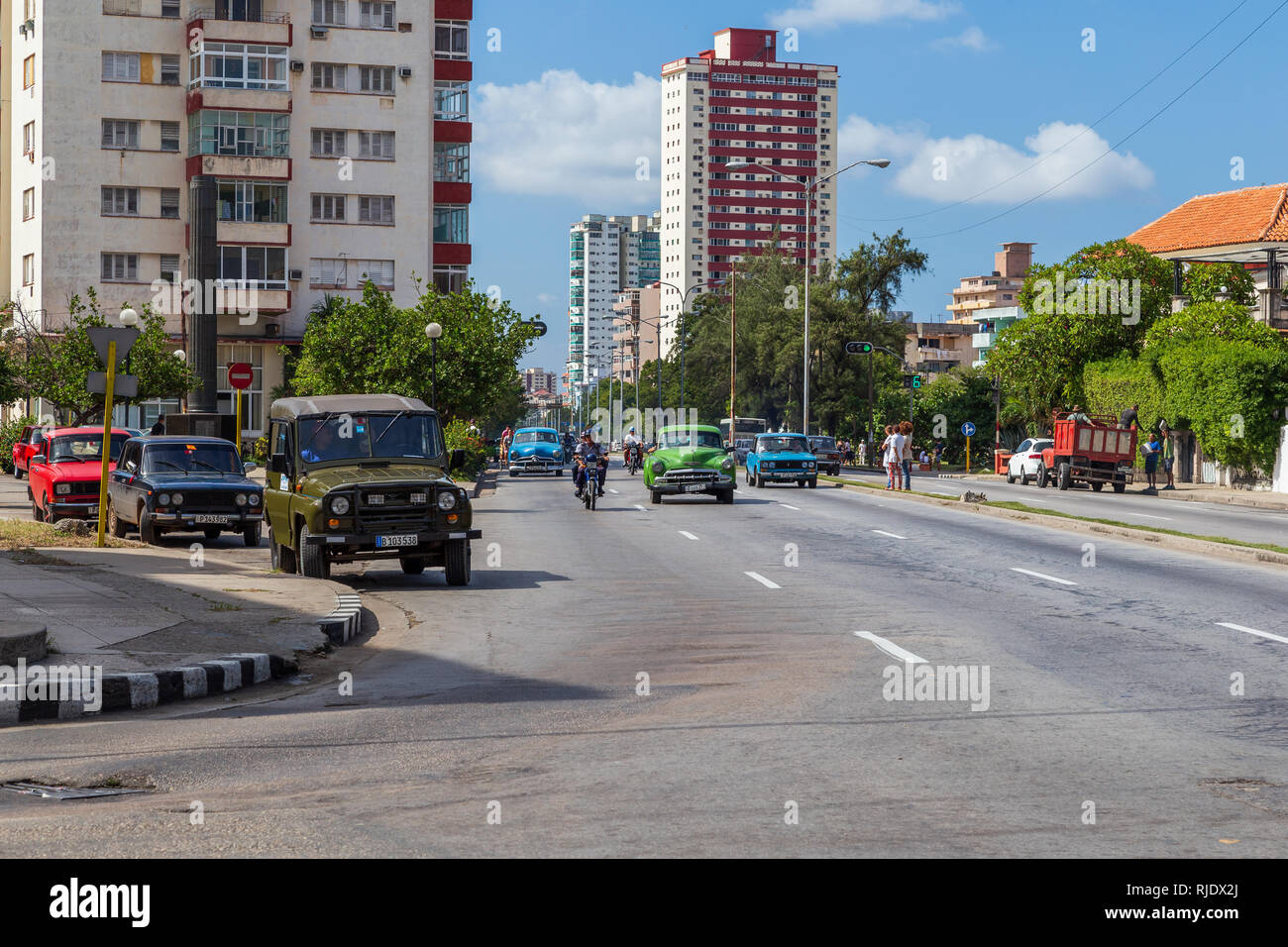 Modernen Gebäuden auf Linea Straße in Havanna, Kuba mit Straßenverkehr und eine Mischung aus alten Sowjetischen russischen Autos und alte amerikanische Autos und Motorräder Stockfoto