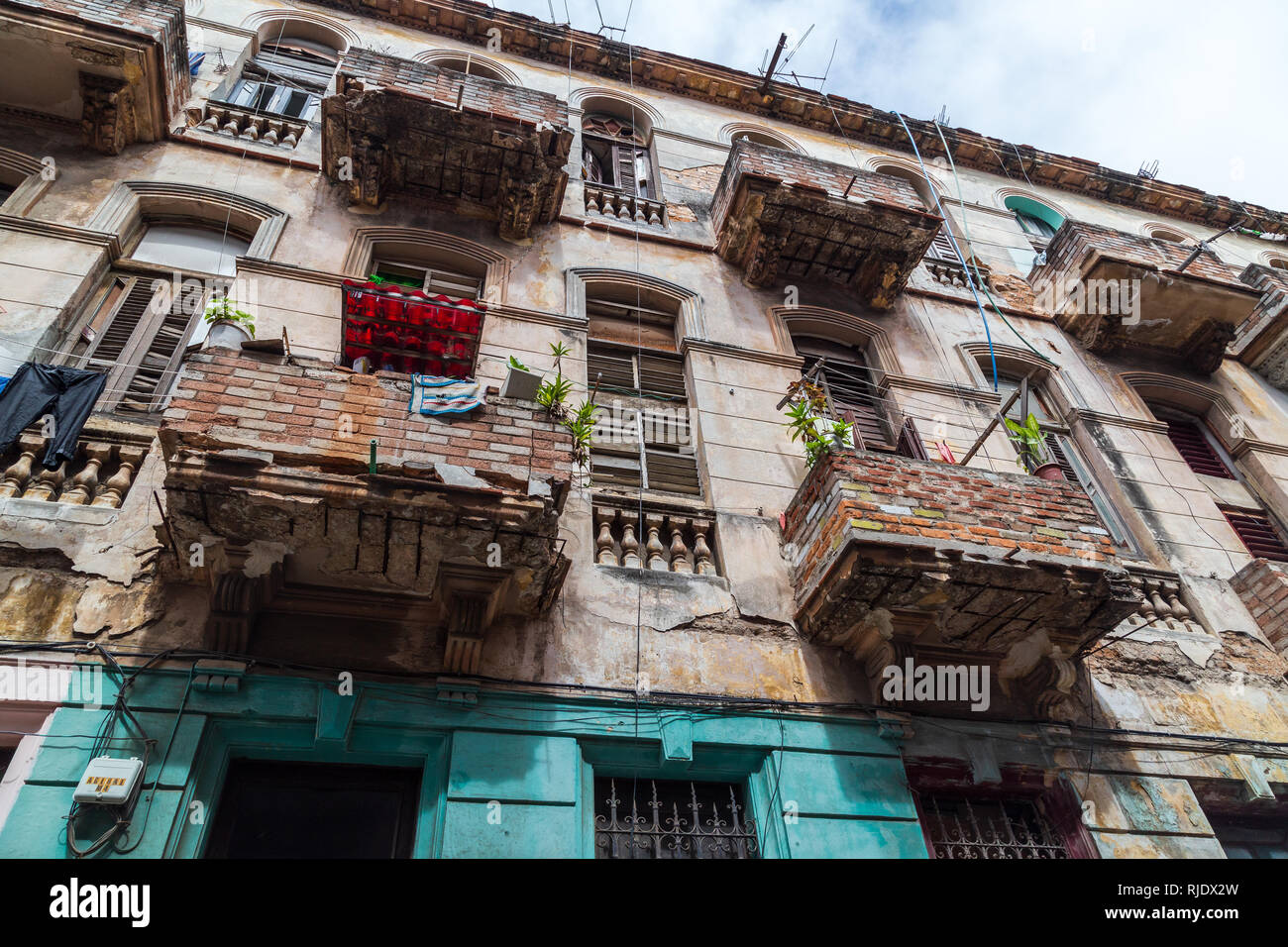 Alten und verfallenen alten Gebäude in der Altstadt von Havanna (La Habana Vieja) mit beschädigten Balkons, von den Bewohnern mit Ziegel wiederhergestellt Stockfoto