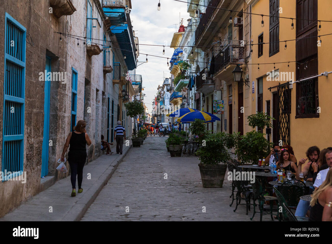 Szene auf eine typische Gasse in der Altstadt in Havanna in Kuba. Die lokale Bevölkerung entlang wandern und Touristen und Kubaner Speisen außerhalb der ein Restaurant Stockfoto