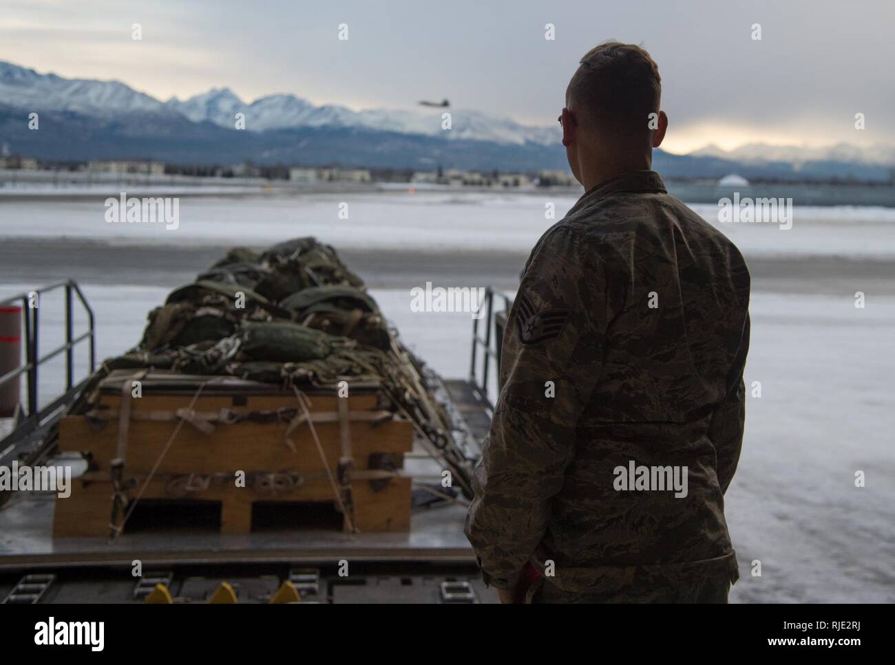 Us Air Force Staff Sgt. Douglas Moye, 773 d Logistik Bereitschaft Squadron bekämpfen Mobilität Supervisor, überwacht die Abreise der Ladung Paletten auf einem halvorsen Lader an Joint Base Elmendorf-Richardson, Alaska, 18.01.2018. Die halvorsen Loader ist eine schnell einsetzbare, hoch mechanisierte Flugzeuge Lader, der Transport und die bis zu 25.000 Pfund Ladung anheben und auf militärische und zivile Flugzeuge Last erreichen. JBER der Bekämpfung des Mobilität Flug ist die größte in PACAF, die C-130 Hercules und C-17 Globemaster III einseitige Airdrop und airland Training für zwei Flügel und drei Staffeln während Stockfoto