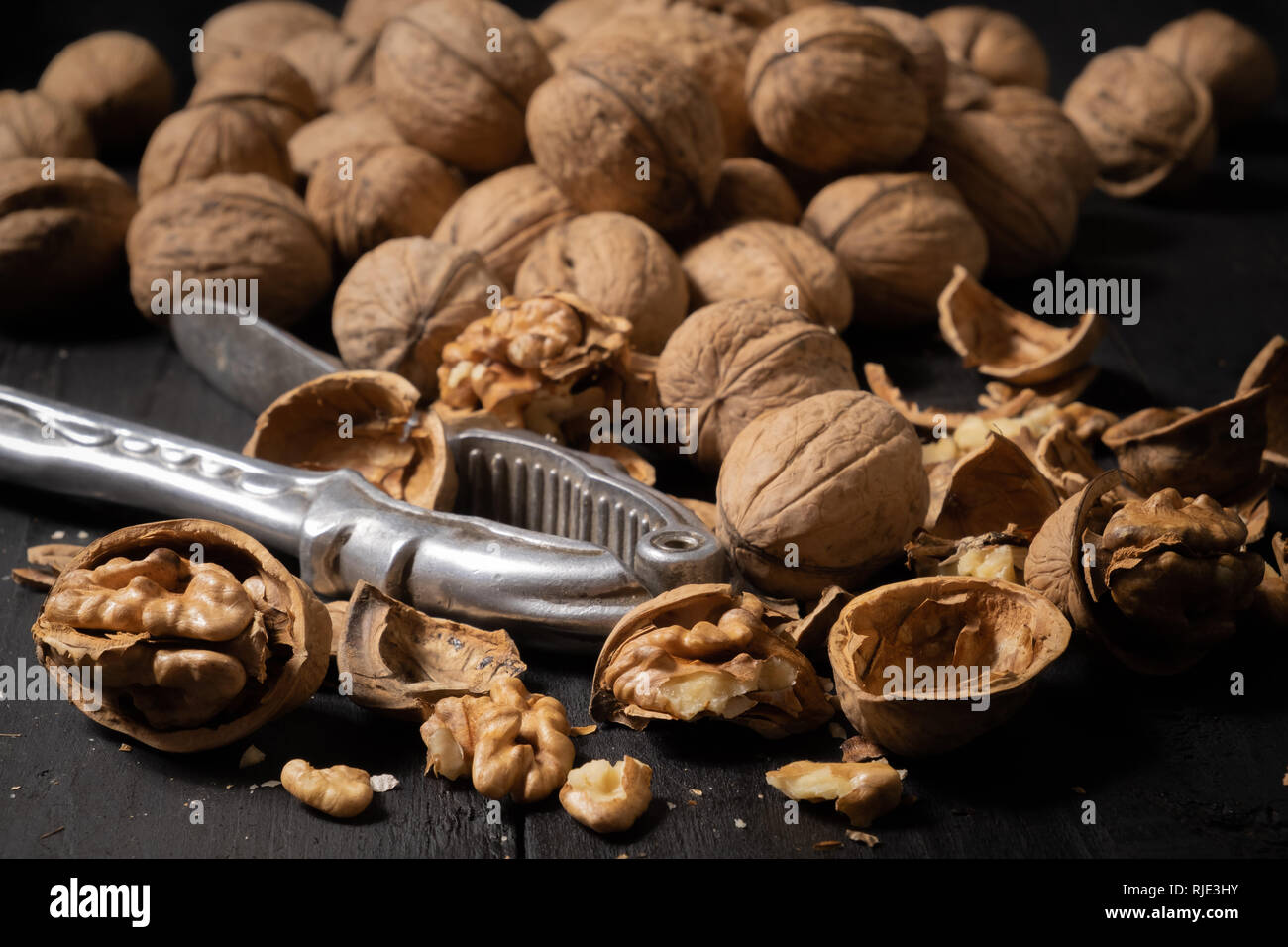 Walnüsse auf dunklem Hintergrund. Low-key-Bild der Muttern auf Schwarz rustikale Tische, Licht und Schatten Technik Stockfoto