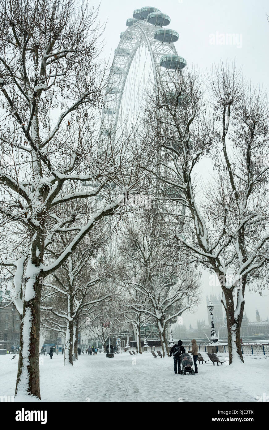 Malerischer Blick auf das London Eye Riesenrad und die umliegenden Bäume im Schnee bedeckt. Stockfoto