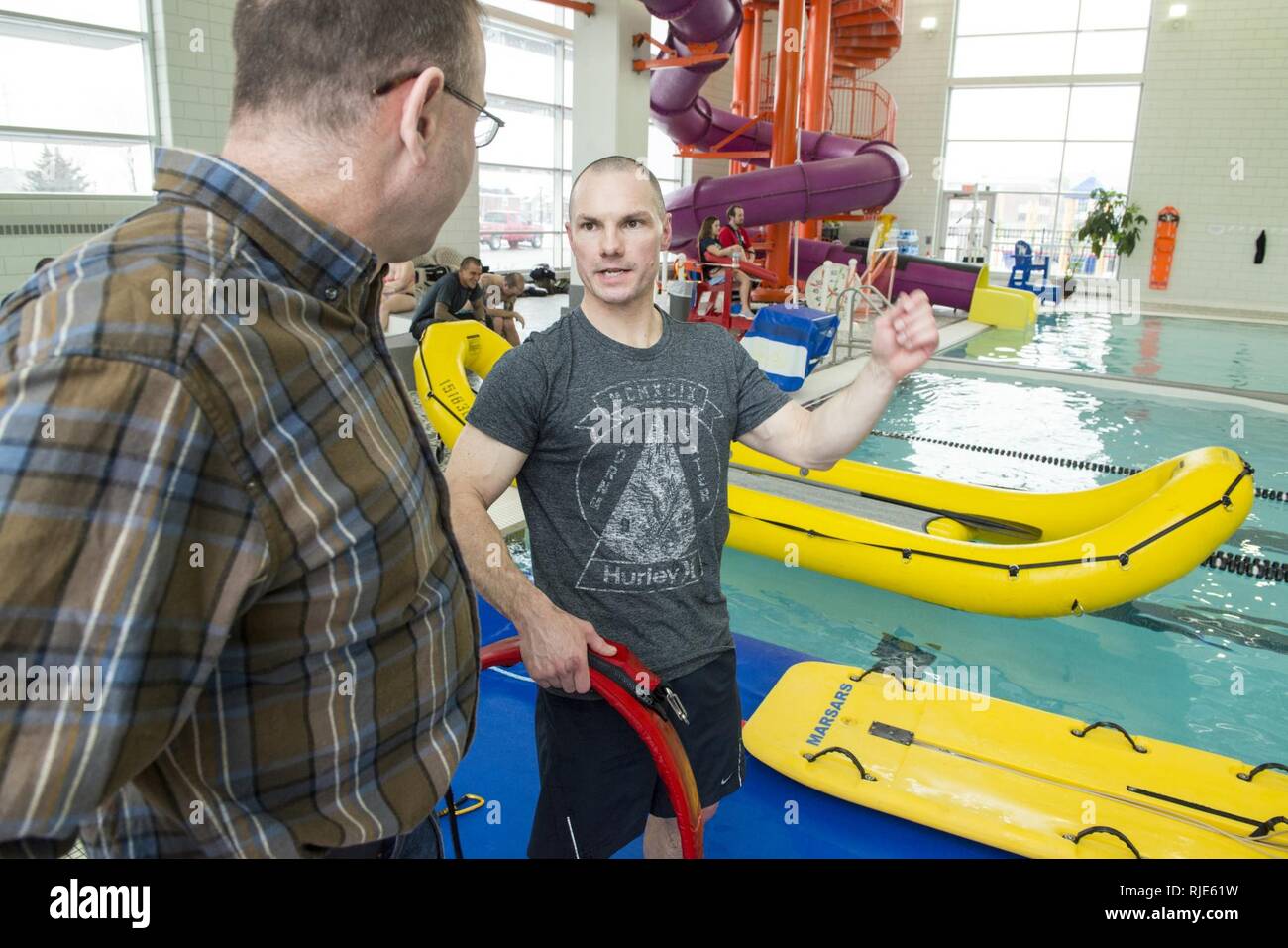 Kapitän Joseph McGilley, die Antwort Division Chief für die Neunte Küstenwache Bezirk Gespräche mit Senior Chief Petty Officer Joel Sayers, einer Luftfahrt überleben Techniker der Air Station Kodiak, über das Eis rescue Training statt, Jan. 18, 2018 in Bay City, Michigan und McGilley Sayers wurden Ausbildung an der National Ice Rettung Schule. Stockfoto