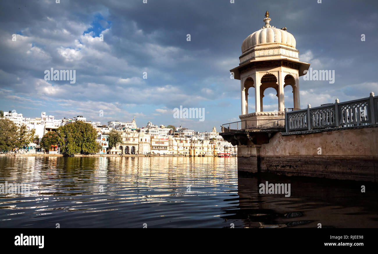 Weißer Turm mit Bögen in der Nähe von Lake Pichola bei bewölktem Himmel in Udaipur, Rajasthan, Indien Stockfoto