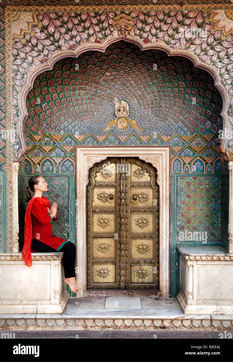 Frau in rot Schal in der Nähe von Lotus Gate im City Palace Jaipur, Rajasthan, Indien sitzen Stockfoto