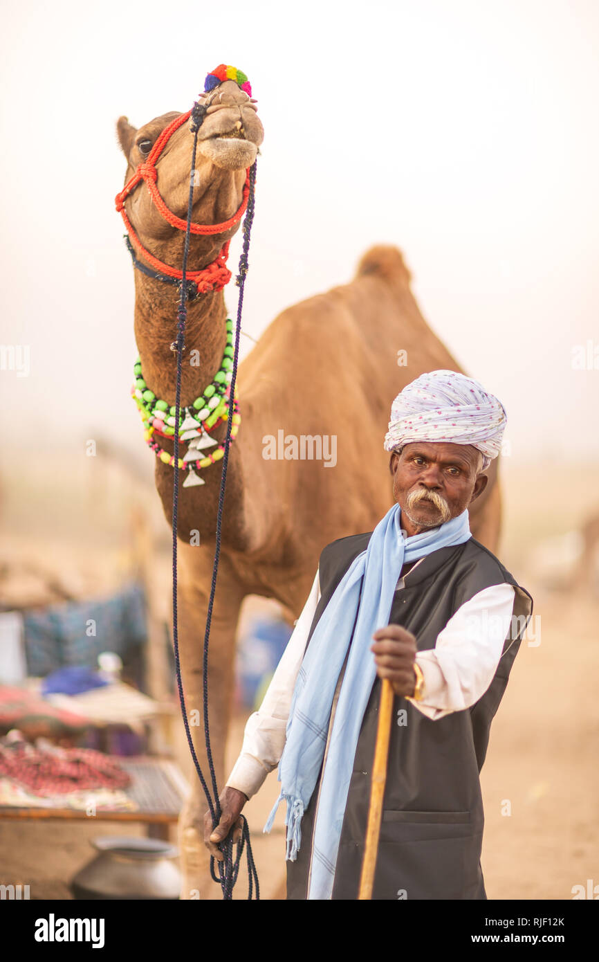 Indische Männer und sein Kamel in der Wüste Thar in Pushkar Kamel Mela in der Nähe der heiligen Stadt Pushkar. Diese Messe ist die größte Camel Trading Messe der Welt. Stockfoto