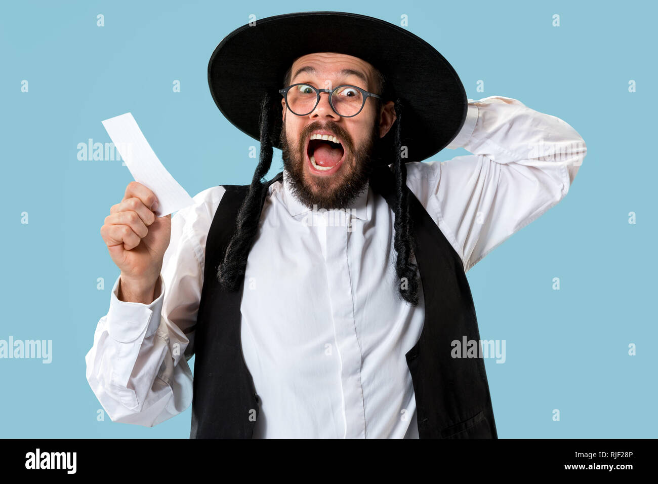 Portrait einer jungen orthodoxen Hasdim jüdischen Mann mit Wettschein im Studio. Das Holiday, Celebration, Judentum, Wette, Wetten. Stockfoto