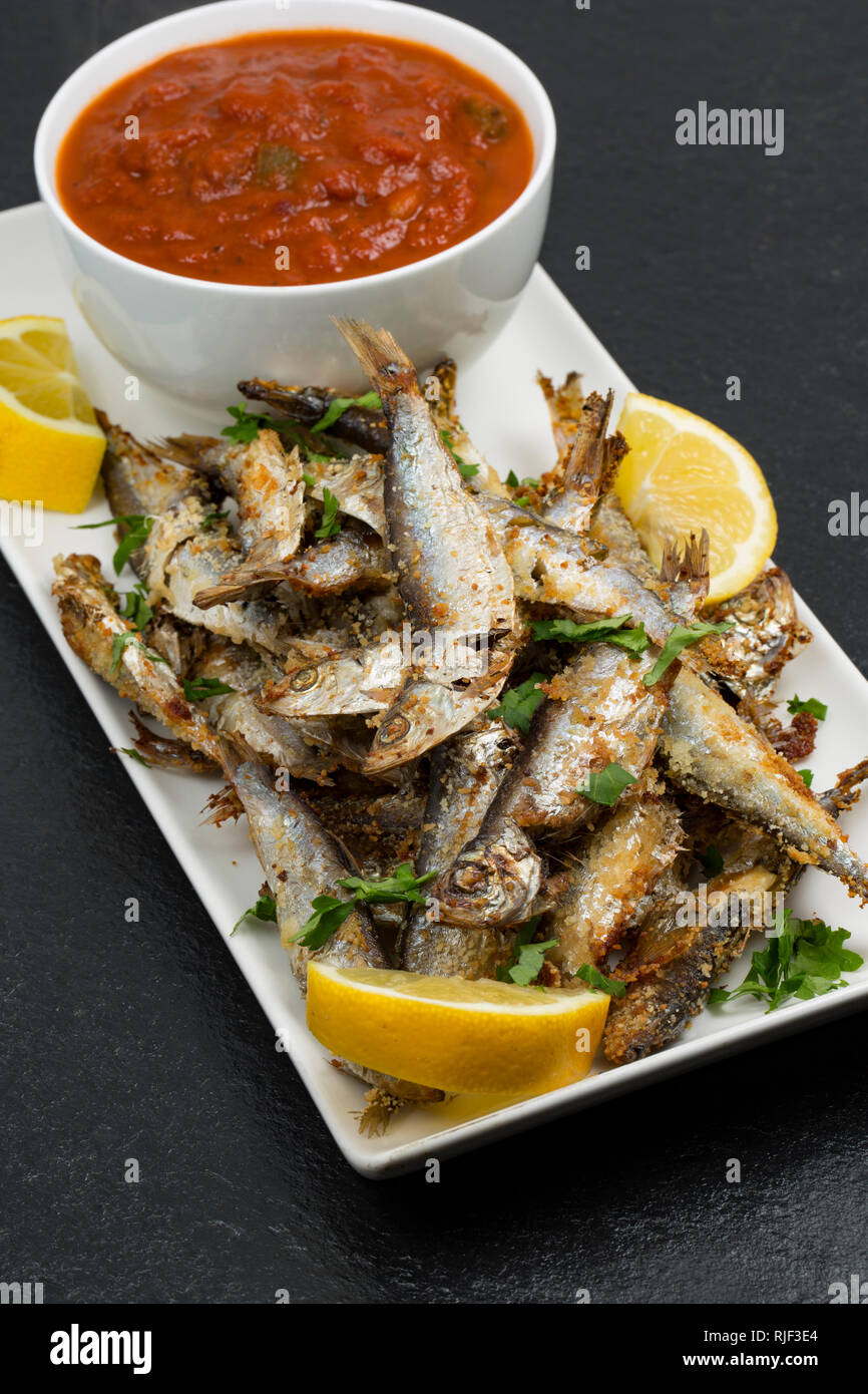 Hausgemachte Sprotten, Sprattus sprattus, aus einem Supermarkt, die mit oilve Öl- und Paniermehl, garniert mit Zitrone Keile und flache l gegrillt wurden. Stockfoto