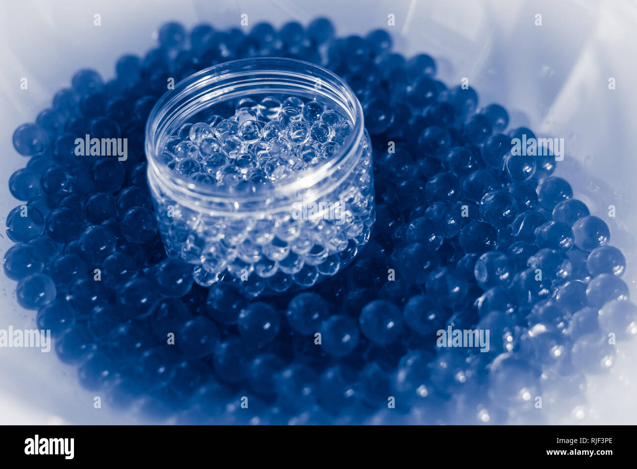 Topf von transparenten Kugeln auf Blue Water gel Kugeln mit Bokeh. Polymer gel Silica Gel. Blau hydrogel Kugeln. Liquid Crystal Ball mit Reflexion. Blue te Stockfoto
