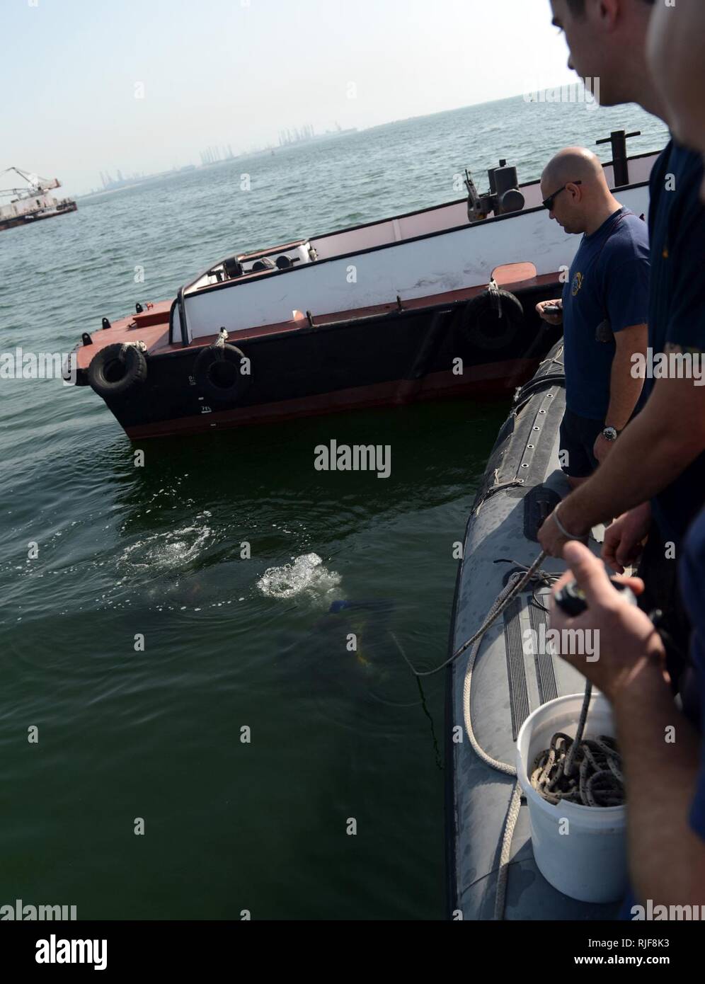 MINA SALMAN PIER, Bahrain (Jan. 24, 2013) Marine Taucher zu mobilen Tauchen und Bergung (MDSU) 2, 2-2, die tendenziell Line Control und für Taucher warten, während eine Routine zur Oberfläche - Terrorismus Force Protection dive zugeordnet. MDSU 2 ist es, Commander, Task Group 56.1 zugewiesen, die Förderung der Mine Countermeasure, Beseitigung von Explosivstoffen, bergung Tauchen und Schutz in den USA 5 Flotte Verantwortungsbereich. Stockfoto