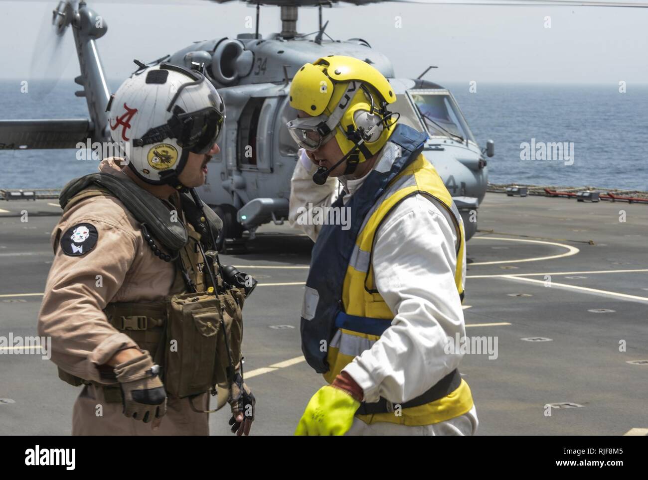 Schiffe Warrant Officer Steve Cooper spricht mit einem Besatzungsmitglied aus SH-60 Sea Hawk, Hubschrauber Meer Combat Squadron 26 gegründet aus Norfolk, während ein Passagier an Bord Transfer RFC Cardigan Bay als Teil der internationalen Mine Gegenmaßnahmen Übung (IMCMEX) 13. IMCMEX umfasst Marinen aus mehr als 40 Ländern, deren Schwerpunkt ist die regionale Sicherheit durch meine Gegenmaßnahmen arbeiten in den USA 5 Flotte Verantwortungsbereich zu fördern. Stockfoto