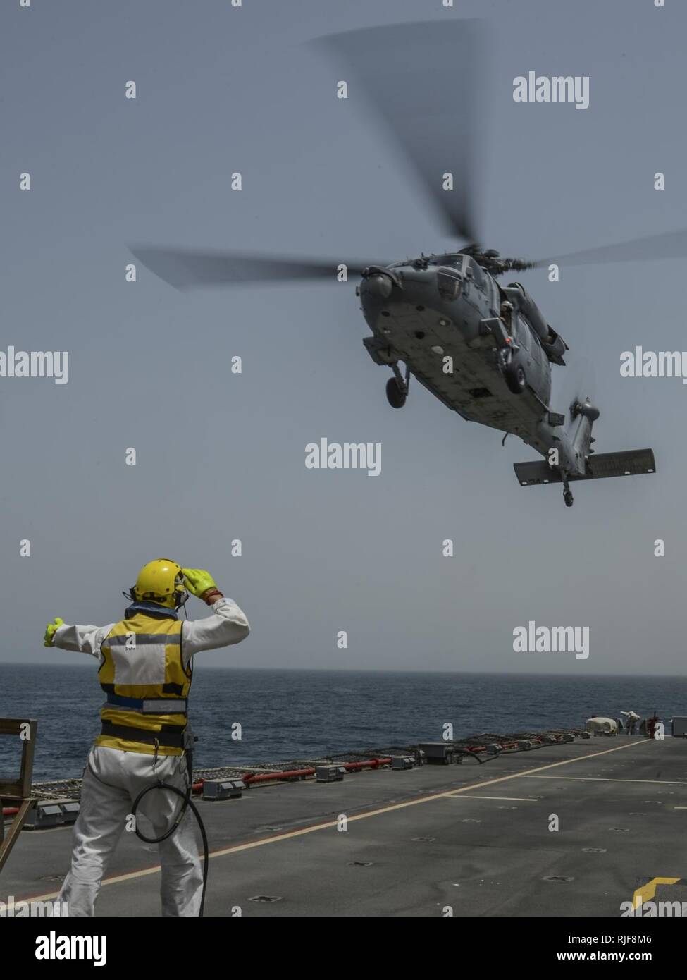 Schiffe Warrant Officer Steve Cooper Signale an ein SH-60 Sea Hawk, Hubschrauber Meer Combat Squadron 26 gegründet aus Norfolk, während Flugbetrieb an Bord RFC Cardigan Bay als Teil eines Pkw transfer während der Internationalen Mine Gegenmaßnahmen Übung (IMCMEX) 13. IMCMEX umfasst Marinen aus mehr als 40 Ländern, deren Schwerpunkt ist die regionale Sicherheit durch meine Gegenmaßnahmen arbeiten in den USA 5 Flotte Verantwortungsbereich zu fördern. Stockfoto