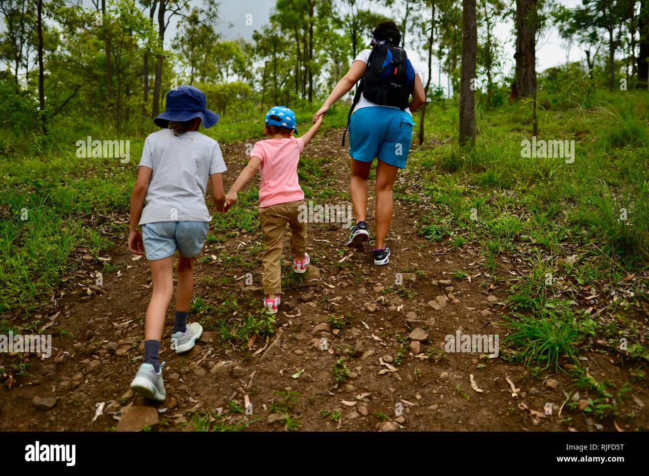 Junge Kinder im Schulalter entlang einem Feldweg, Moongun Wanderweg am Elliot Federn, Townsville, Queensland, Australien Stockfoto