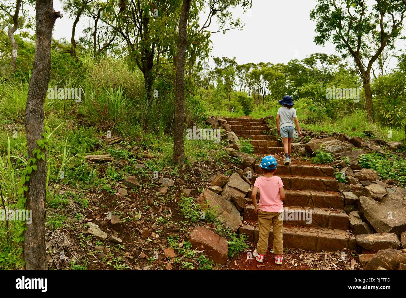 Junge Kinder im Schulalter entlang einem Feldweg, Moongun Wanderweg am Elliot Federn, Townsville, Queensland, Australien Stockfoto