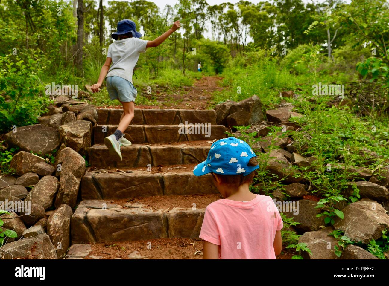 Junge Kinder im Schulalter entlang einem Feldweg, Moongun Wanderweg am Elliot Federn, Townsville, Queensland, Australien Stockfoto