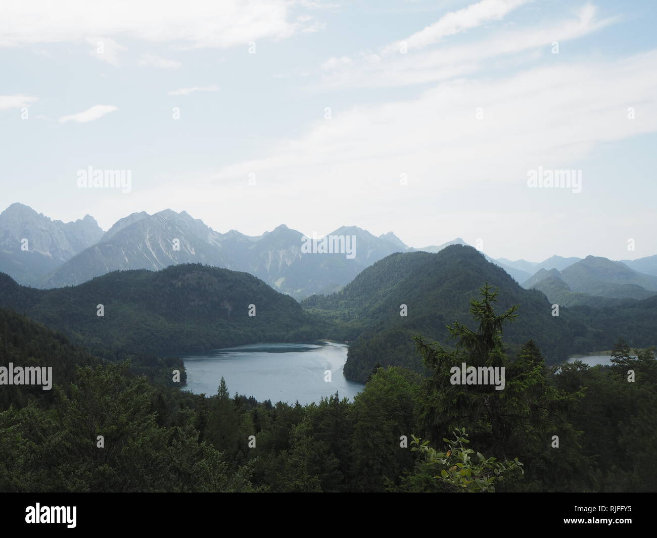 Ein blauer See sitzt, von einer Bergkette in den Bayerischen Alpen auf einer deutschen Sommer Tag umgeben. Stockfoto