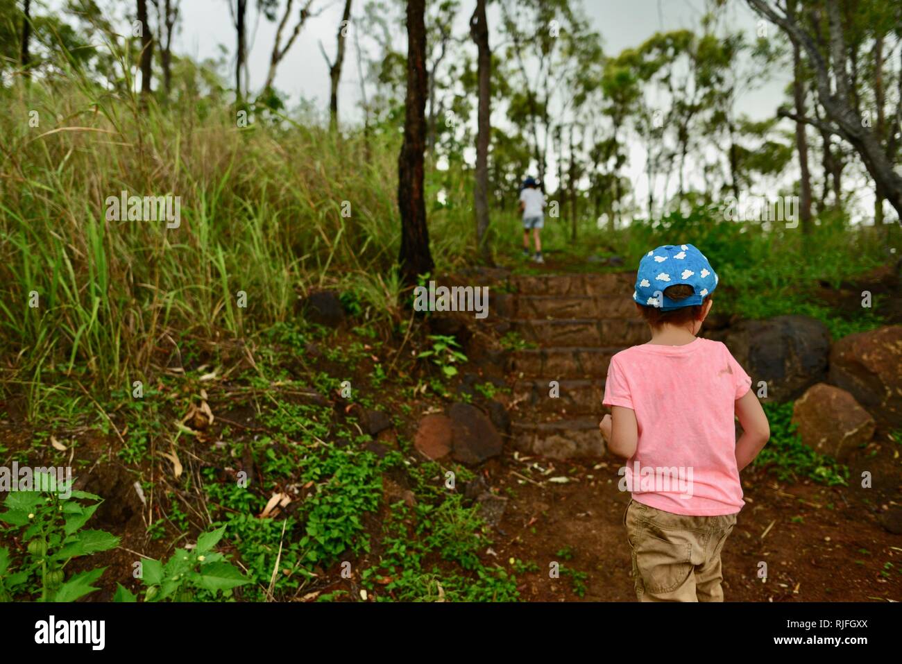 Junge Kinder im Schulalter entlang einem Feldweg, Moongun Wanderweg am Elliot Federn, Townsville, Queensland, Australien Stockfoto